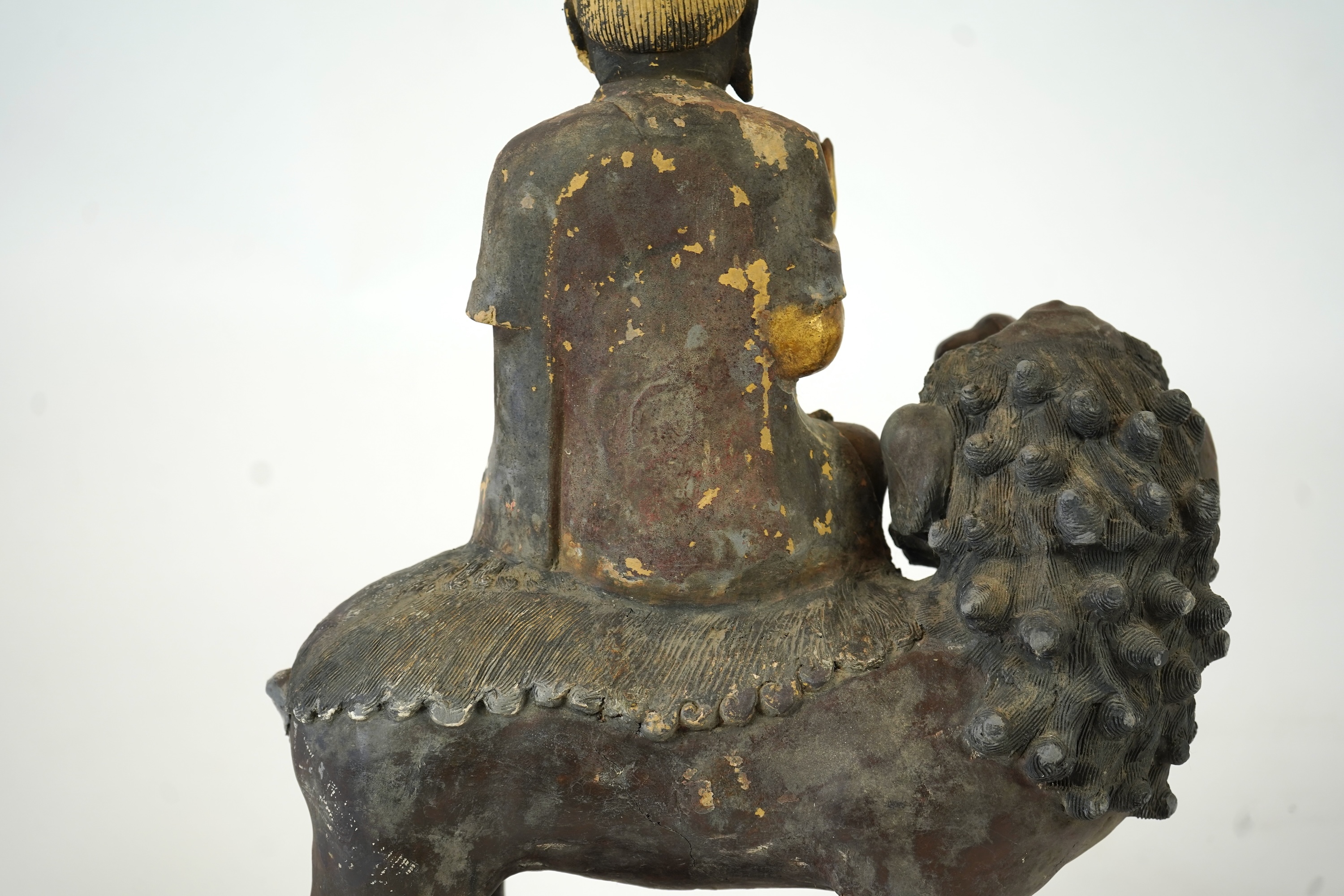 A Chinese gilt and polychrome lacquered stucco work and wood figure of Manjushri on a lion, Yuan-Ming dynasty